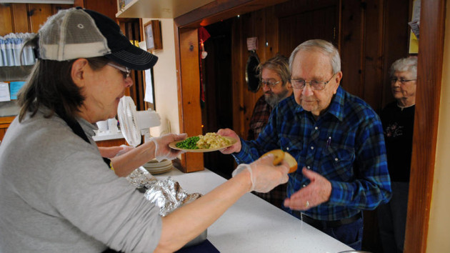 Marti Ollanketo serves Melvin Larson on Thursday at the Appleton meal site. West Central Tribune photo by Tom Cherveny