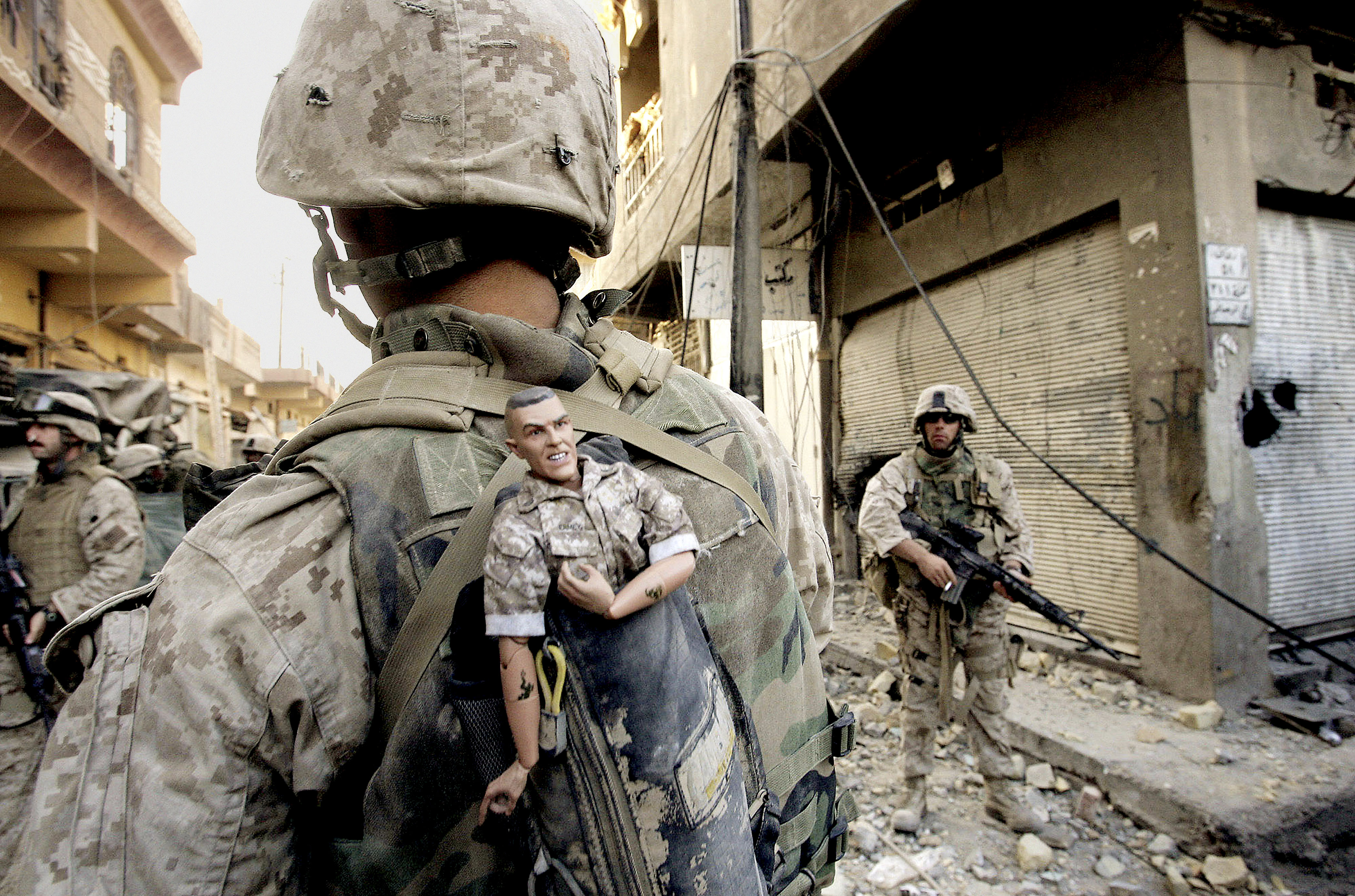 This photograph is one in a portfolio of twenty taken by eleven different Associated Press photographers throughout 2004 in Iraq.  A U.S. Marine of the 1st Division carries a mascot for good luck in his backpack as his unit pushed further into the western part of Fallujah, Iraq, Sunday, Nov. 14, 2004. The Associated Press won a Pulitzer prize in breaking news photography for the series of pictures of bloody combat in Iraq. The award was the AP's 48th Pulitzer. (AP Photo/Anja Niedringhaus)