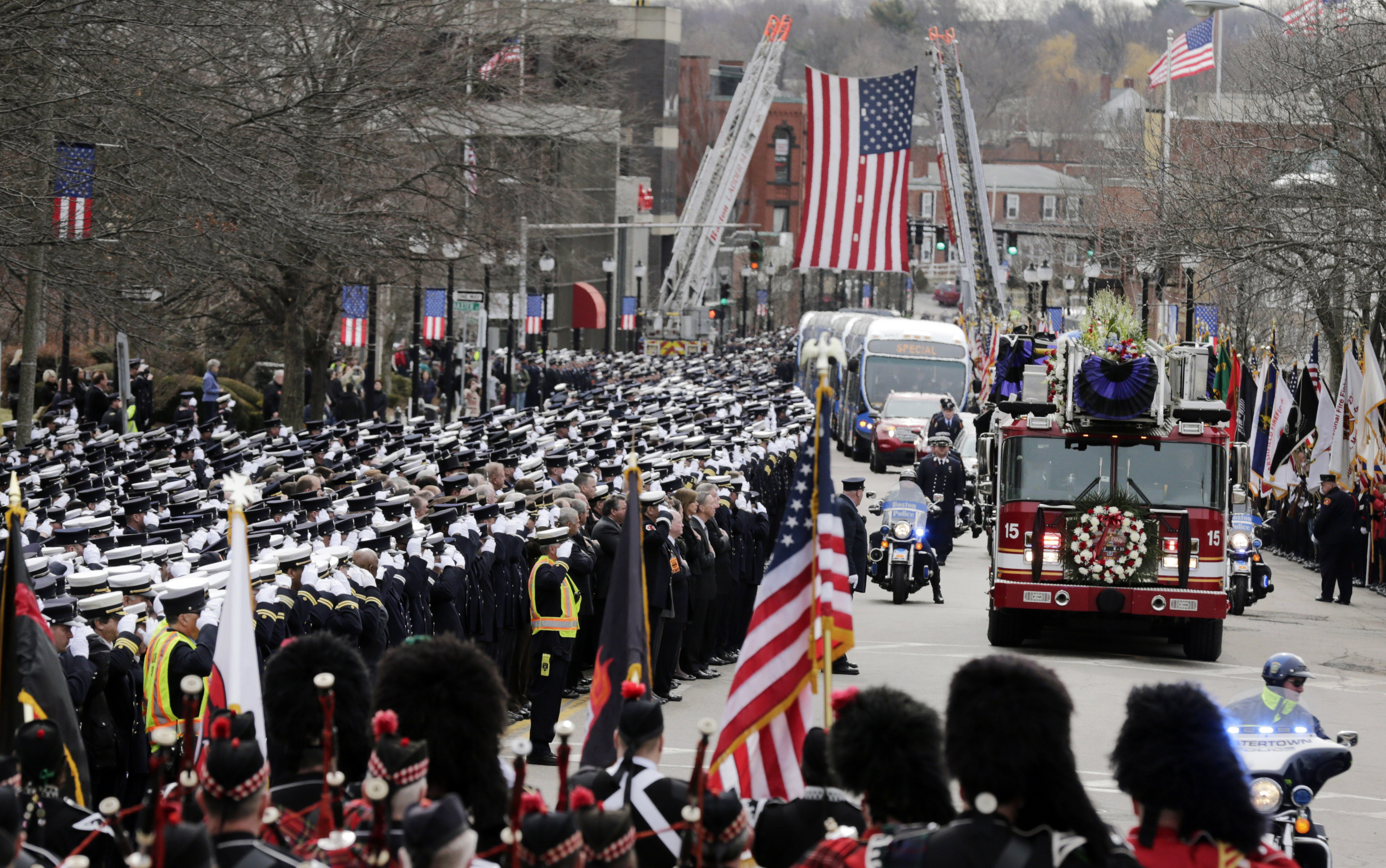 Firefighters salute as the funeral procession for Boston fire Lt. Edward Walsh arrives outside St. Patrick's Church in Watertown, Mass., Wednesday, April 2, 2014. Walsh and his colleague Michael Kennedy died after being trapped while battling a nine-alarm apartment fire in Boston on March 26. (AP Photo/Charles Krupa)