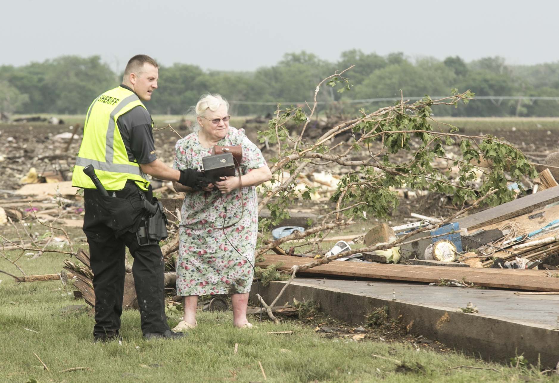 Ruth Labenz is assisted to safety by a Stanton County Sherriff's officer after her home was destroyed in the town of Pilger, Neb. Monday, June 16, 2014. At least one person is dead and at least 16 more are in critical condition after two massive tornadoes swept through northeast Nebraska on Monday. (AP Photo/Mark 'Storm' Farnik)