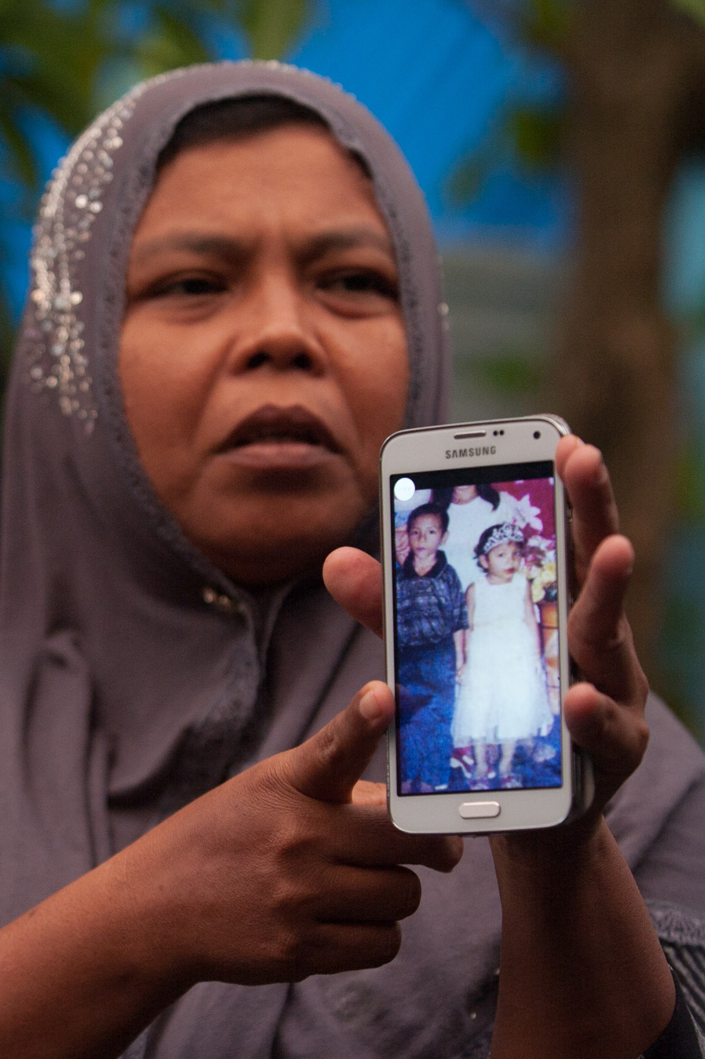 Indonesian mother Jamaliah displays a picture taken before the 2004 tsunami of her two missing children, daughter Raudhatul Jannah (R) and son Arif Pratama Rangkuti (L). Photo: Chaideer Mahyuddin//AFP/Getty Images.