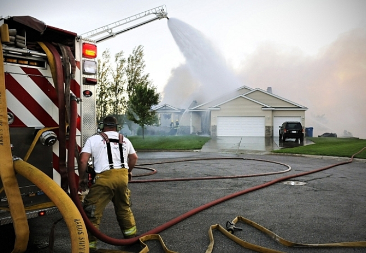 Firefighters work to get the flames under control after a small plane crashed into a home at 731 Garden Place in Sauk Rapids, Minn., Friday, June 20, 2014. (AP Photo/St. Cloud Times, Jason Wachter)
