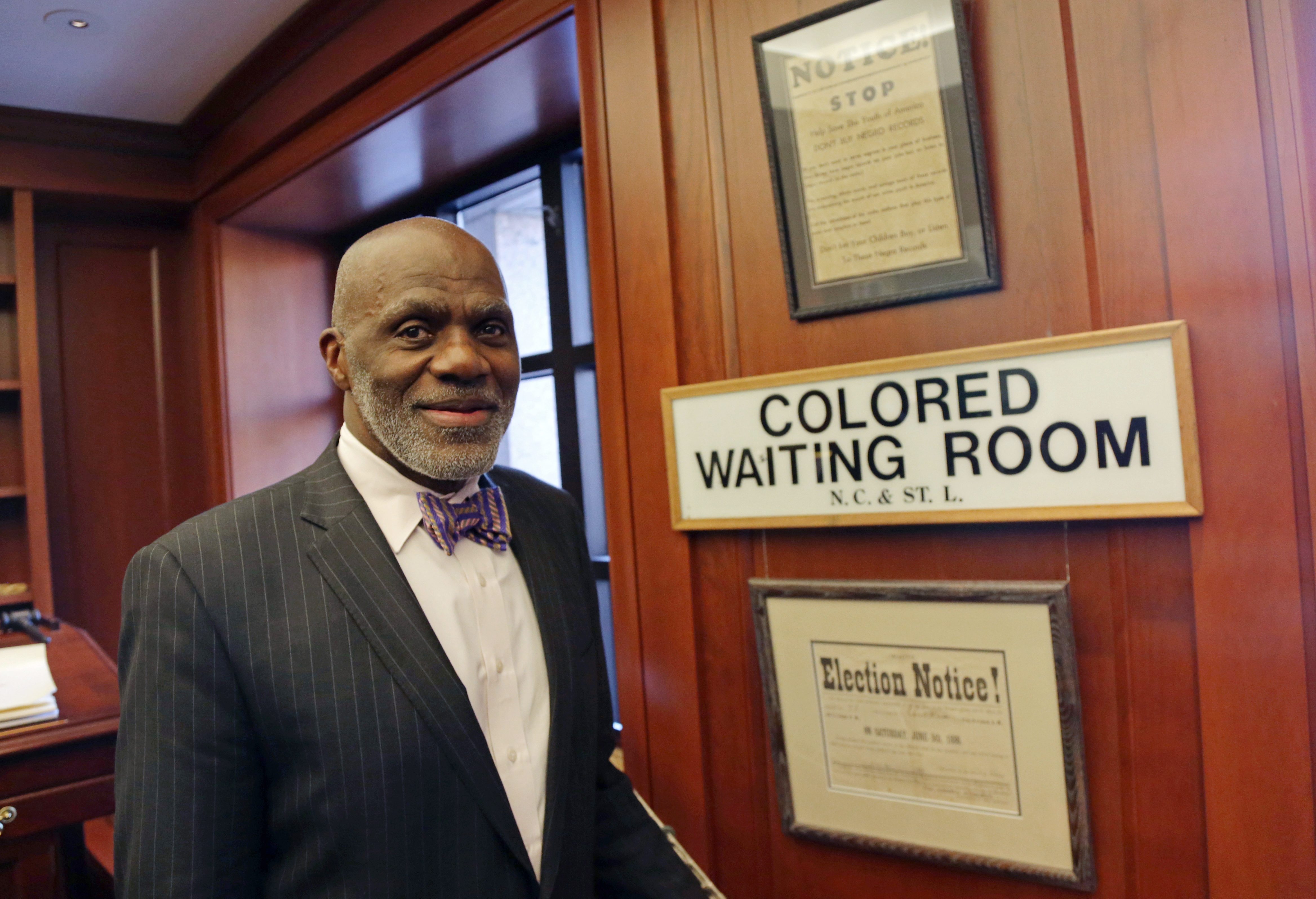 In this Jan 15, 2015, photo, Minnesota Supreme Court Justice Alan Page poses in his chambers hes decorated with some jarring reminders of the segregation era, such as a Colored Waiting Room sign from a southern railroad, during an interview  in St. Paul, Minn. Page hits the mandatory retirement age of 70 later this year.  (AP Photo/Jim Mone)