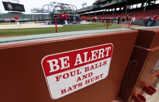 A warning sign is displayed in the stands at Fenway Park before a baseball game between the Boston Red Sox and the Oakland Athletics in Boston, Saturday, June 6, 2015. A woman was hit and seriously injured by a broken bat during the game on Friday. (AP Photo/Michael Dwyer)