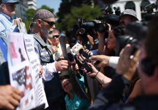 John Miller speaks in favor of the Confederate flag to the media during a rally to take down the flag at the South Carolina Statehouse, Tuesday, June 23, 2015, in Columbia, S.C. A crowd gathered Tuesday to demand the removal of the Confederate battle flag from atop a 30-foot pole outside South Carolina's Statehouse.  (AP Photo/Rainier Ehrhardt)