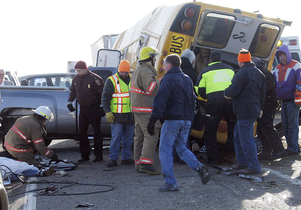 Rescue workers are seen at the site of a bus crash Tuesday Feb. 19, 2008 on Cottonwood, Minn. A crash involving a school bus and other vehicles in southwestern Minnesota has left at least 3 people dead, including a child. (AP File Photo/ Marshall Independent, Rae Kruger)