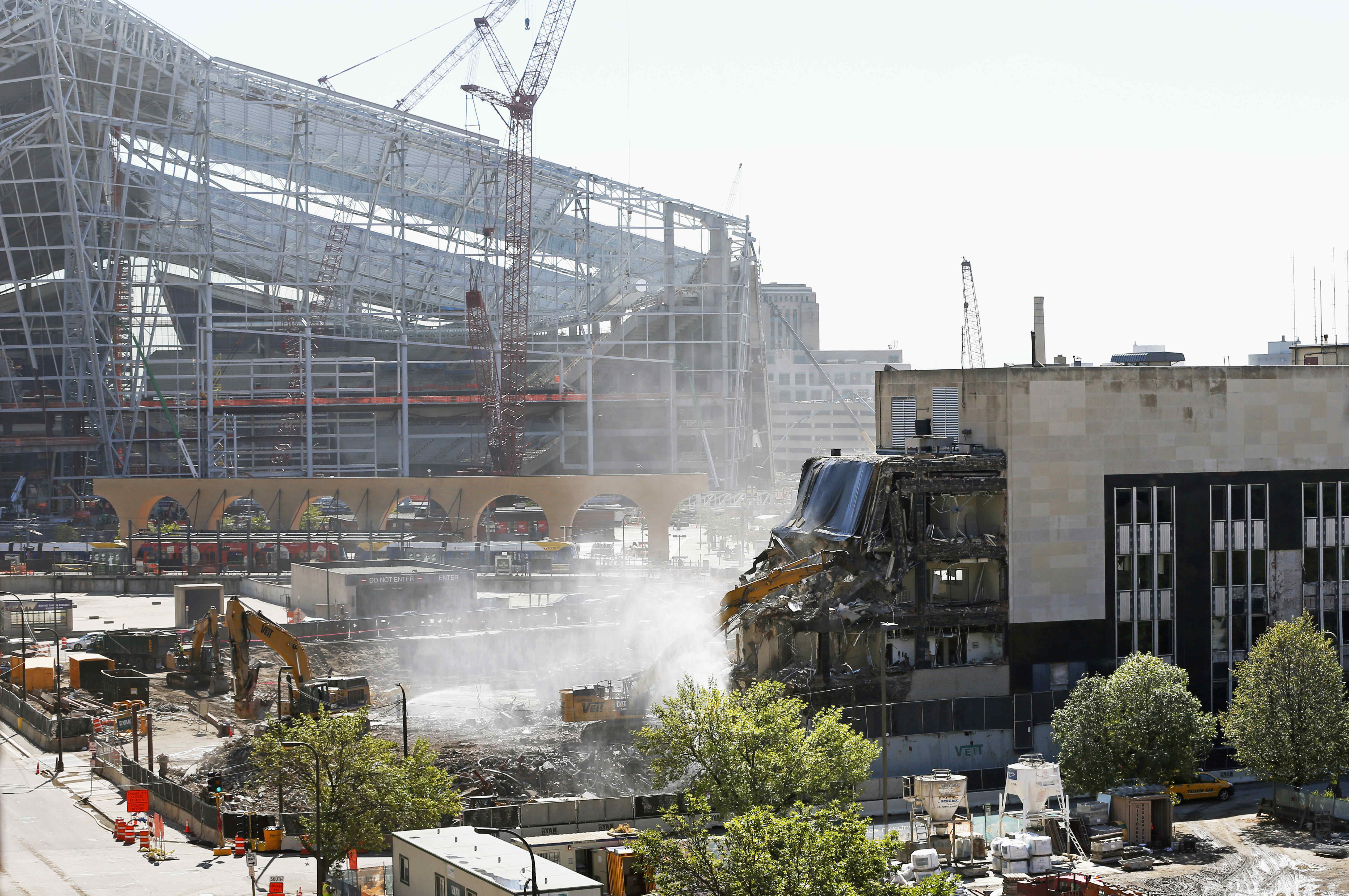 The new U.S. Bank Stadium, home of the Minnesota Vikings NFL football team which opens in 2016, looms in the background as demolition of the Star Tribune building, right, continues Thursday, Sept. 10, 2015, to make room for a park adjacent to the stadium in Minneapolis. The city council is expected to vote Friday on whether to approve the design and fundraising arrangement for the park. (AP Photo/Jim Mone)
