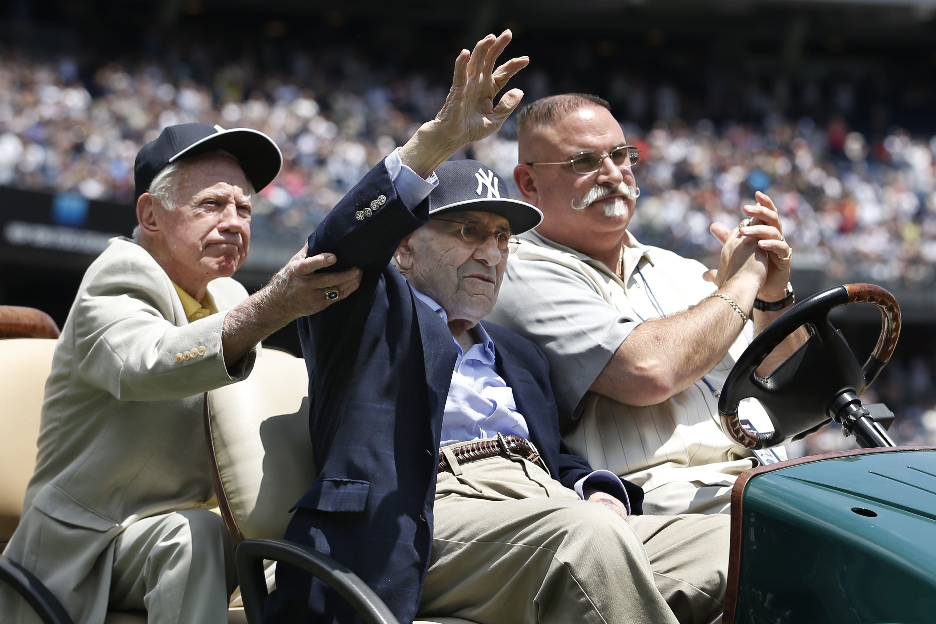 Hall of Fame pitcher Whitey Ford, left, helps former teammate and Hall of Famer catcher Yogi Berra as Berra is introduced during the 68th annual Old Timers Day prior to the Baltimore Orioles baseball game against the New York Yankees at Yankee Stadium in New York, Sunday, June 22, 2014. (AP Photo/Kathy Willens)