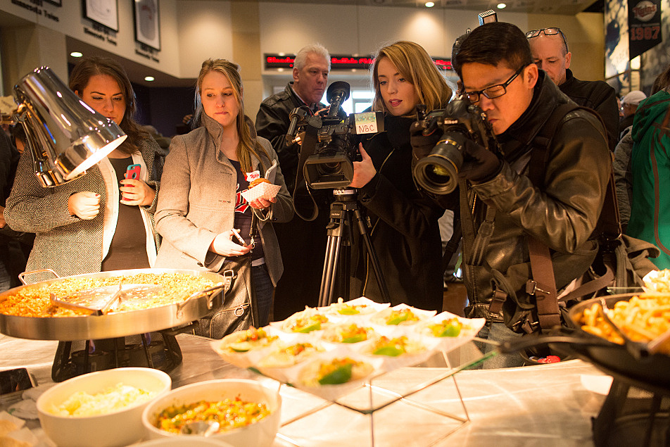 Members of the media crowd around an array of new foods being debuted this year at Target Field. Matthew Hintz for MPR News