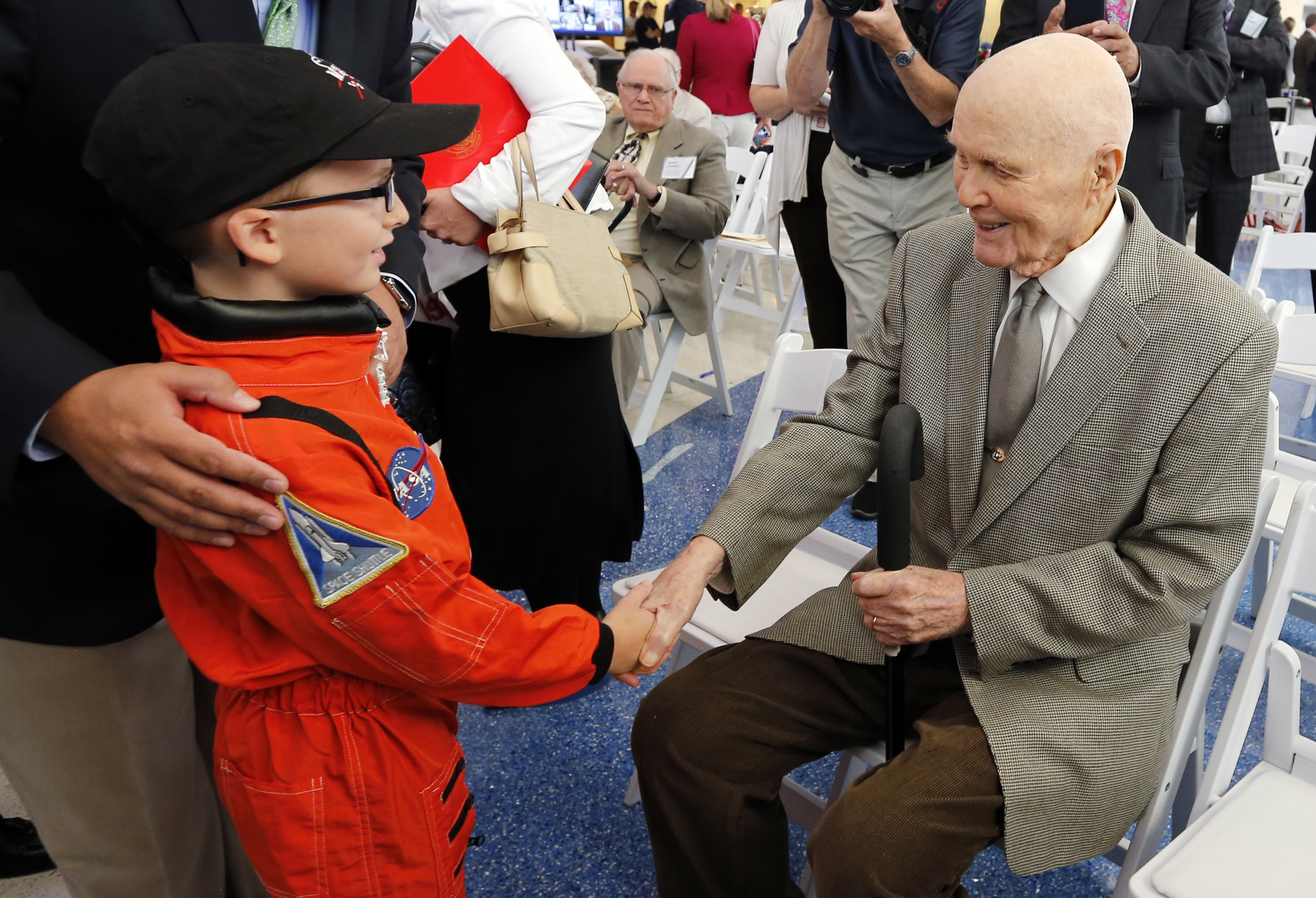 Former U.S. Sen. John Glenn, right, shakes hands with eight-year-old Josh Schick before the start of a celebration for the renaming of Port Columbus International Airport to John Glenn Columbus International Airport Tuesday, June 28, 2016, in Columbus, Ohio. AP Photo/Jay LaPrete.