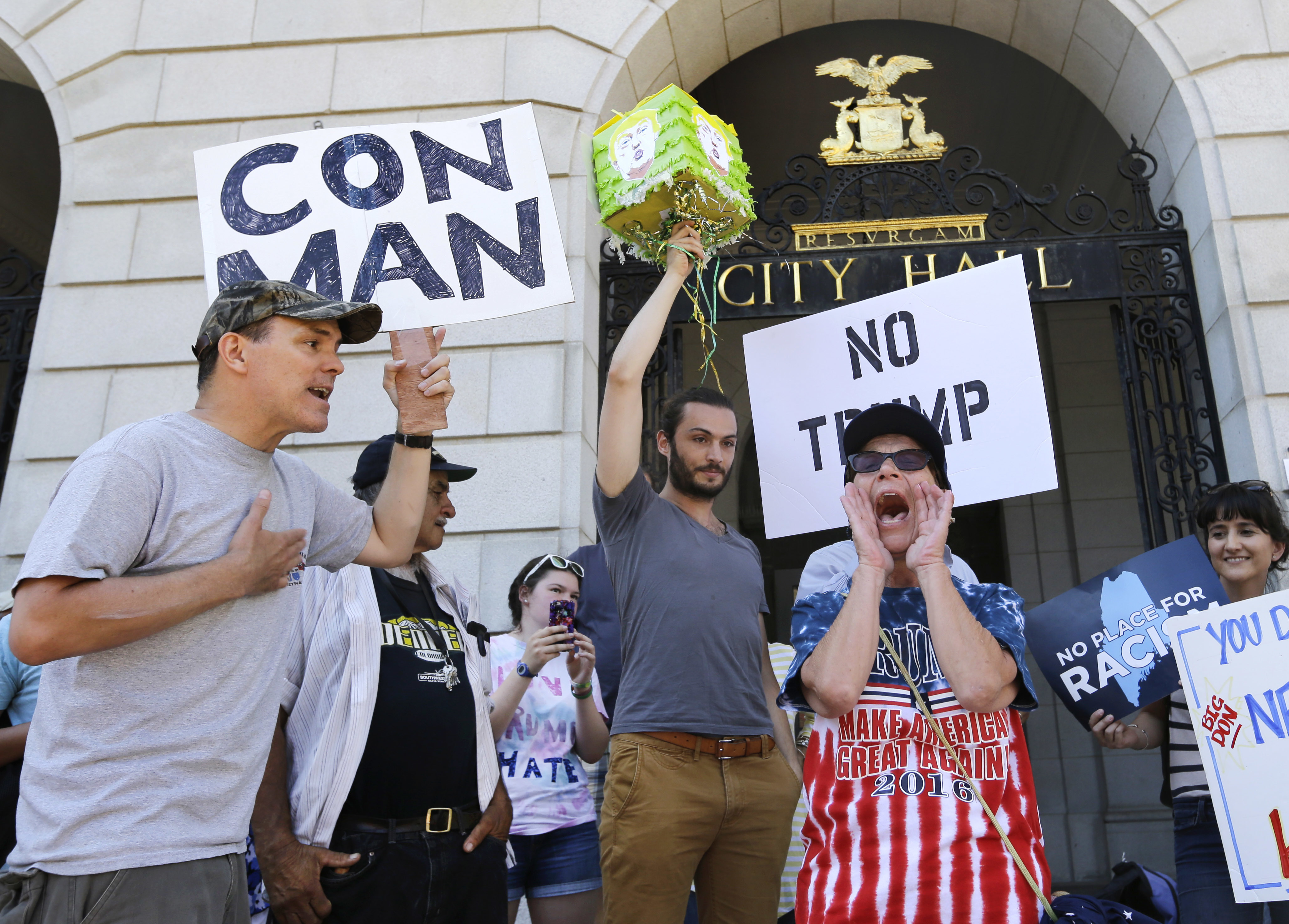 Catherine Ferrell, right, of Greene, Maine, a supporter of Republican presidential candidate Donald Trump, yells as Alex Lange, far left, of Portland, Maine argues with her at a demonstration outside Portland City Hall, Thursday, Aug. 4, 2016, near Trump's campaign appearance at Merrill Auditorium. (AP Photo/Elise Amendola)