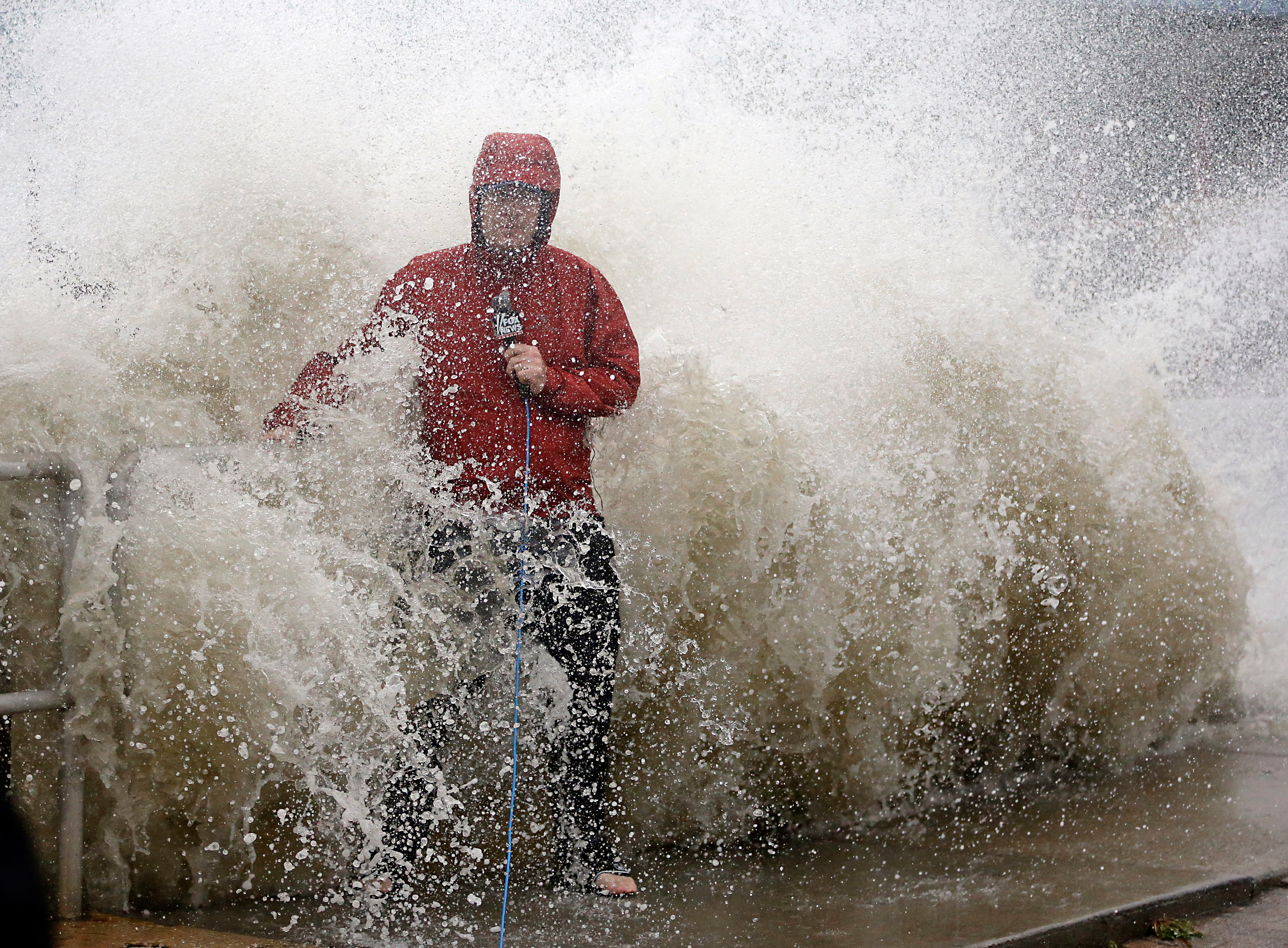 A news reporter doing a stand up near a sea wall in Cedar Key, Fla., is covered by an unexpected wave as Hurricane Hermine neared the Florida coast. AP Photo/John Raoux