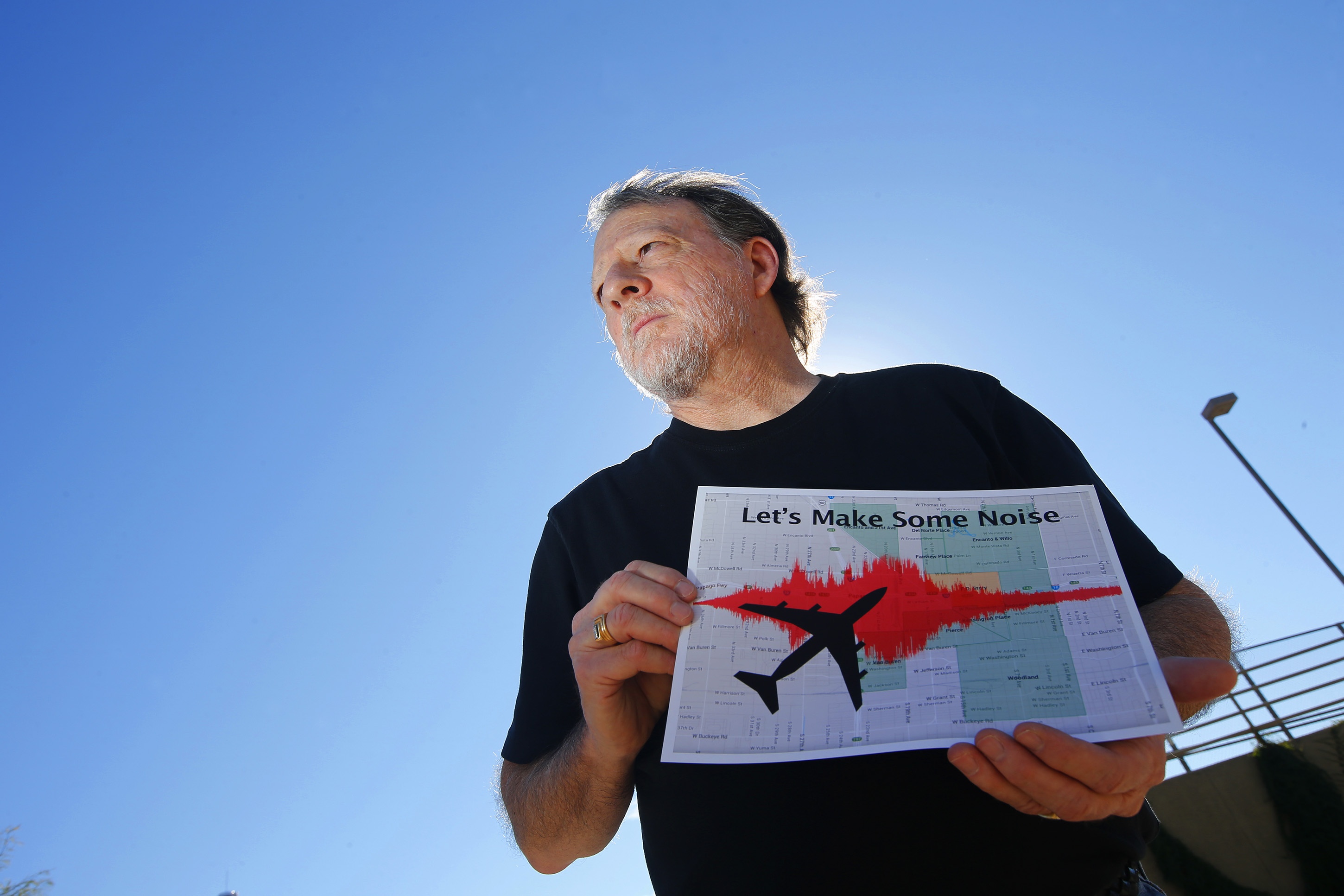 In this Friday, Feb. 6, 2015 photo, Steve Dreiseszun, a resident of the F.Q. Story historic district in Phoenix, holds a graph of the increased noise brought on by airplanes flying along new flight paths out of Phoenix Sky Harbor International Airport and how his neighborhood and dozens like it have been affected by the new noise. (AP Photo/Ross D. Franklin)