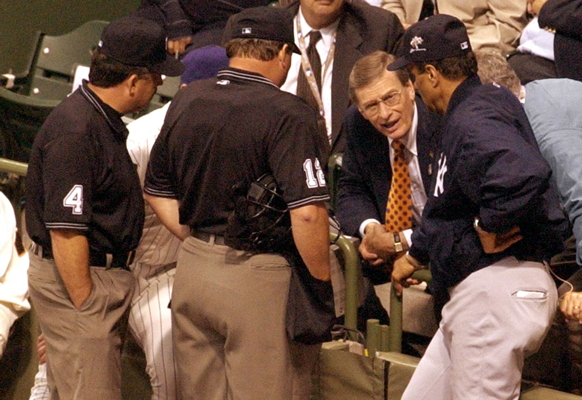 Baseball Commisioner Bud Selig, second from right, talks with American League manager Joe Torre, right, and National League manager Bob Brenly, hidden, as umpires listen during the 11th inning of the All-Star Game in Milwaukee, Tuesday, July 9, 2002. The game was called at the end of the inning with the score tied at 7-7. (AP Photo/Darren Hauck)