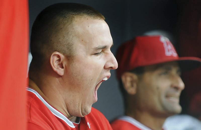 FILE - In this Sept. 19, 2015, file photo, after a 12-inning first game, Los Angeles Angels center fielder Mike Trout yawns on the bench prior to taking the field against the Minnesota Twins for the second game of a baseball doubleheader in Minneapolis. Researchers say they’ve documented an unseen drag on major league baseball players that can wipe out home field advantage, make pitchers give up more home runs, and take some punch out of a team's bats. The culprit: jet lag. AP Photo/Richard Marshall, File.