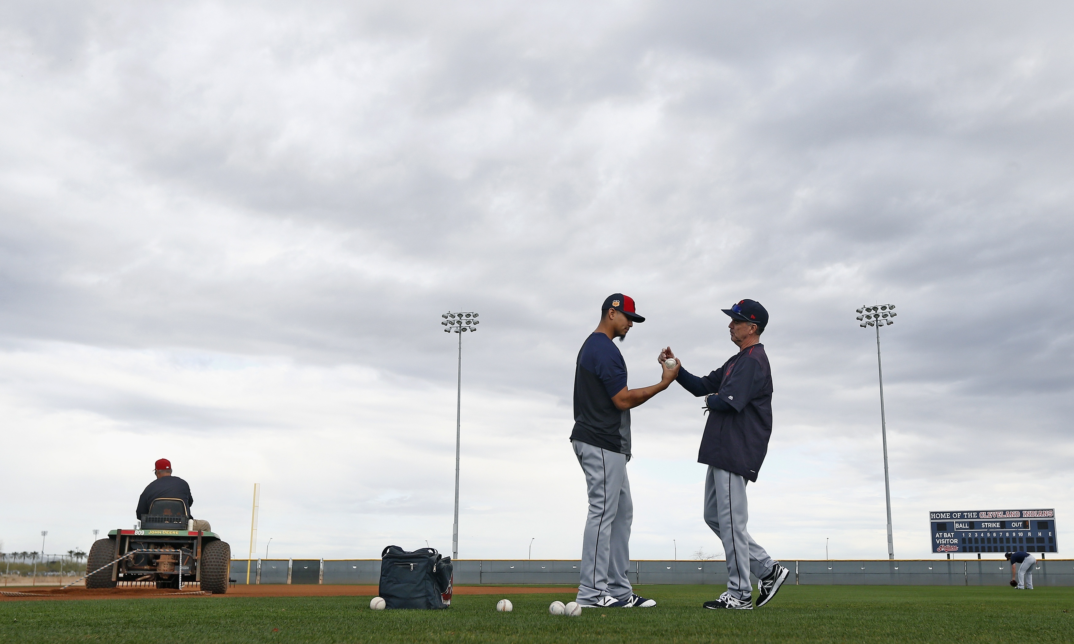 Cleveland Indians pitcher Carlos Carrasco talks with minor league pitching coach Tony Arnold, right, at the Indians baseball spring training facility Monday, Feb. 13, 2017, in Goodyear, Ariz. (AP Photo/Ross D. Franklin)