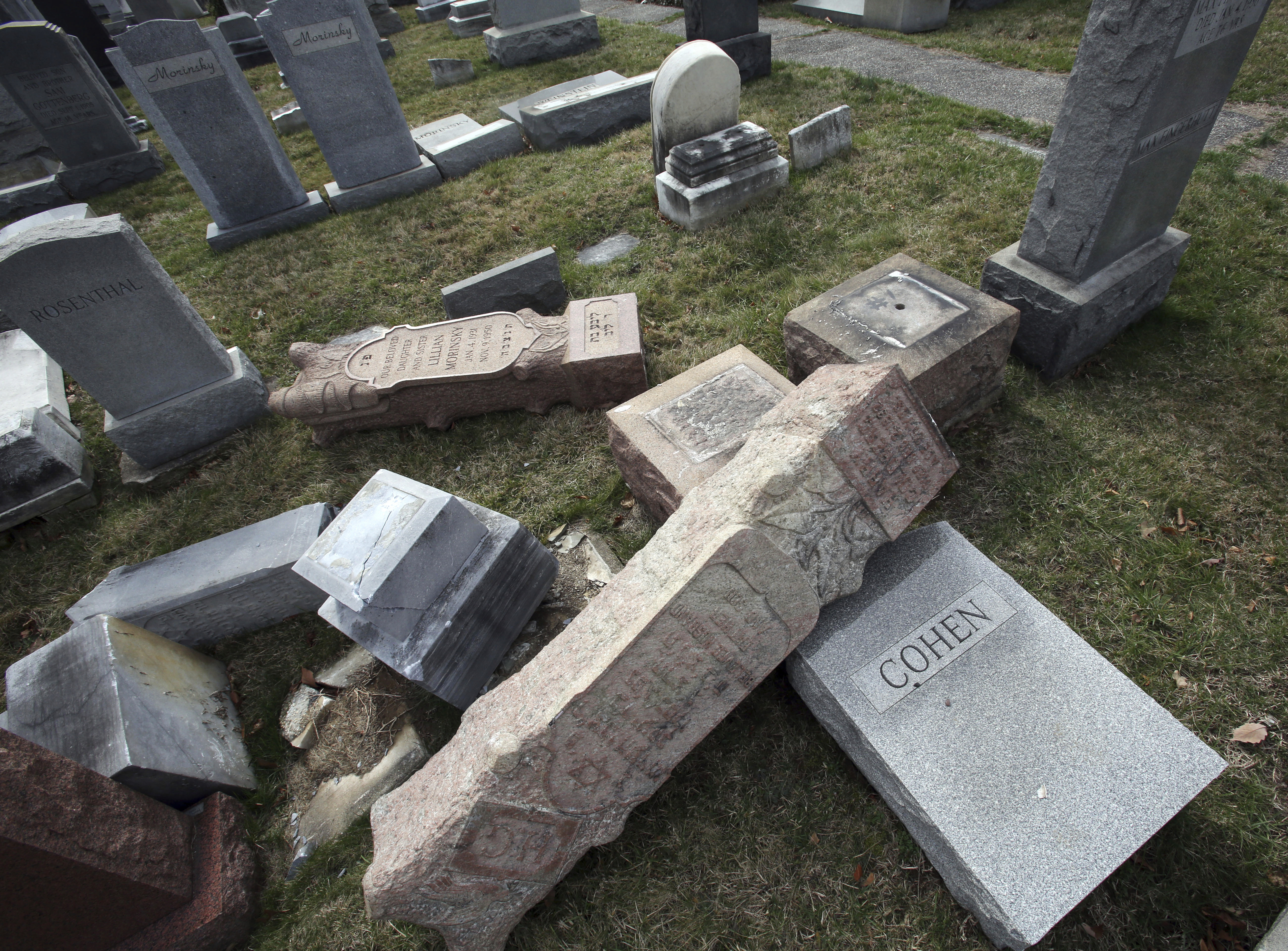 Damaged headstones rest on the ground at Mount Carmel Cemetery on Monday, Feb. 27, 2017, in Philadelphia. More than 100 headstones have been vandalized at the Jewish cemetery in Philadelphia, damage discovered less than a week after similar vandalism in Missouri, authorities said. (AP Photo/Jacqueline Larma)