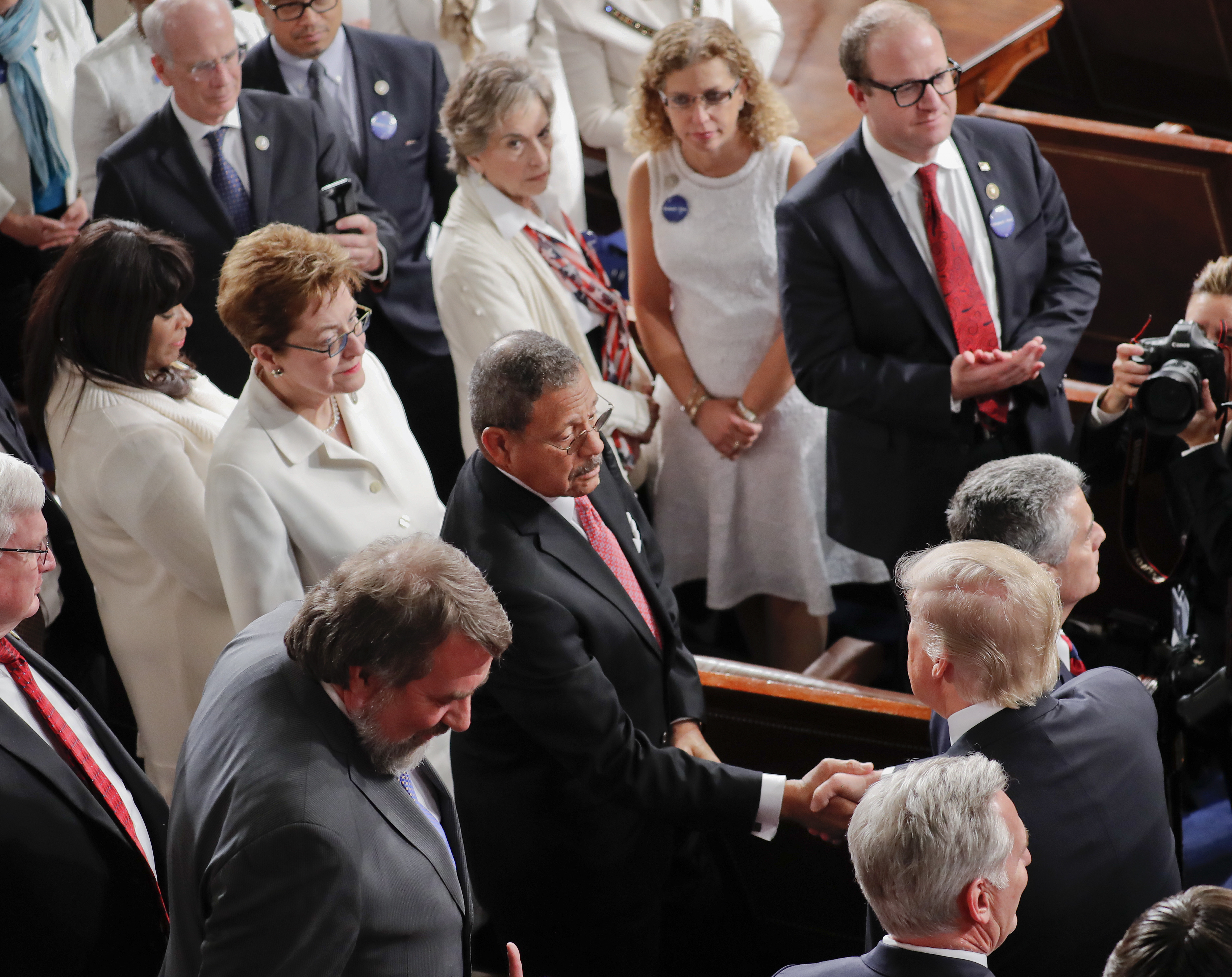 President Donald Trump, lower right, shakes hands with Rep. Sanford Bishop, D-Ga., center, as women Democratic members of Congress, wearing white, watch as Trump arrives on Capitol Hill in Washington, Tuesday, Feb. 28, 2017, to address a joint session of Congress. (AP Photo/Pablo Martinez Monsivais)