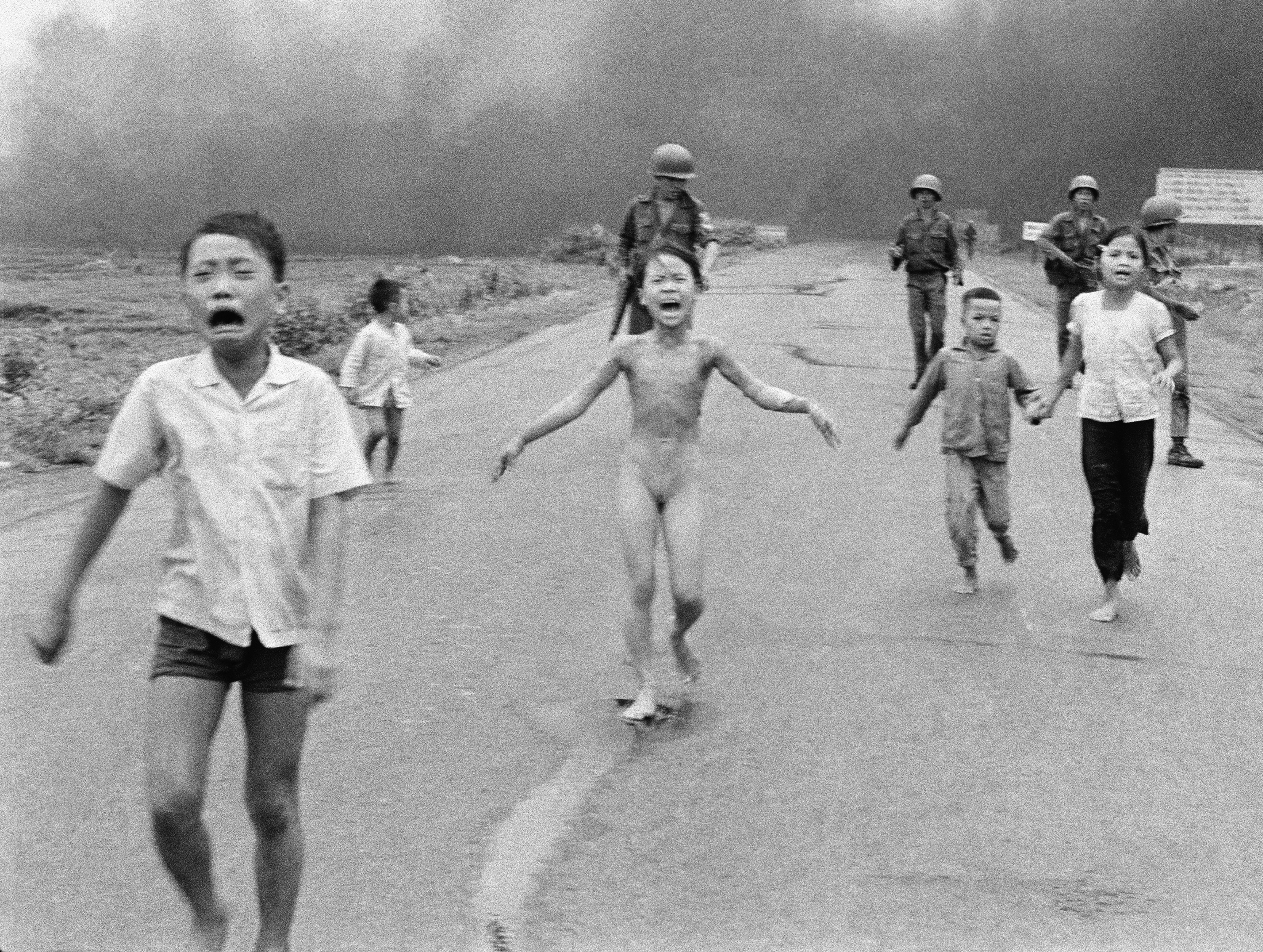 South Vietnamese forces follow after terrified children, including 9-year-old Kim Phuc, center, as they run down Route 1 near Trang Bang after an aerial napalm attack on suspected Viet Cong hiding places on June 8, 1972. A South Vietnamese plane accidentally dropped its flaming napalm on South Vietnamese troops and civilians. The terrified girl had ripped off her burning clothes while fleeing. The children from left to right are: Phan Thanh Tam, younger brother of Kim Phuc, who lost an eye, Phan Thanh Phouc, youngest brother of Kim Phuc, Kim Phuc, and Kim's cousins Ho Van Bon, and Ho Thi Ting. Behind them are soldiers of the Vietnam Army 25th Division. (AP Photo/Nick Ut)