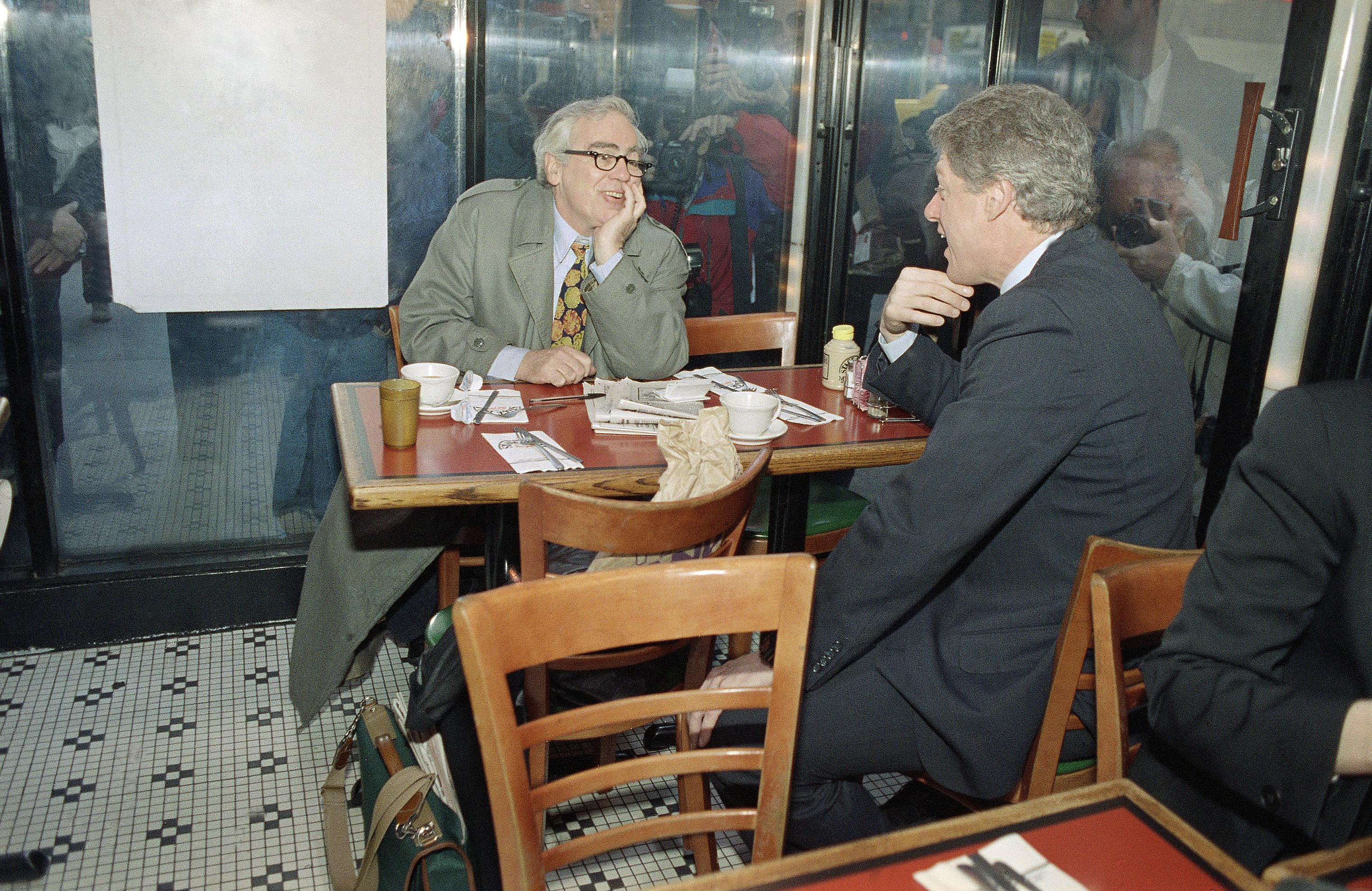 Then Democratic presidential hopeful Gov. Bill Clinton of Arkansas has a cup of coffee with newspaper columnist Jimmy Breslin at New York's Stage Deli, April 6, 1992. Stephan Savoia | Associated Press.