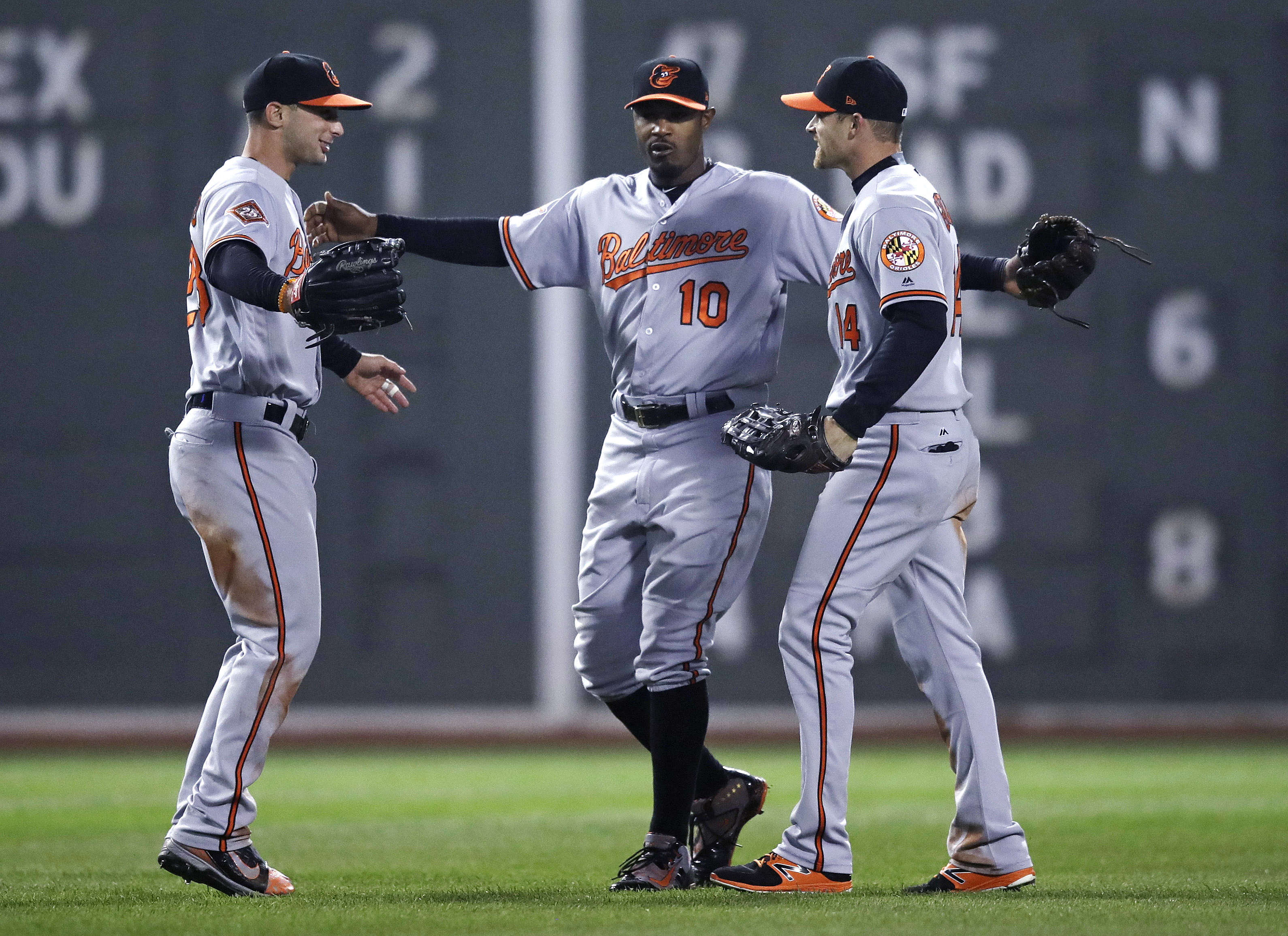 Baltimore Orioles center fielder Adam Jones (10) celebrates with right fielder Craig Gentry, right, and left fielder Joey Rickard left, after defeating the Boston Red Sox 5-2 during a baseball game at Fenway Park in Boston, Monday, May 1, 2017. (AP Photo/Charles Krupa)