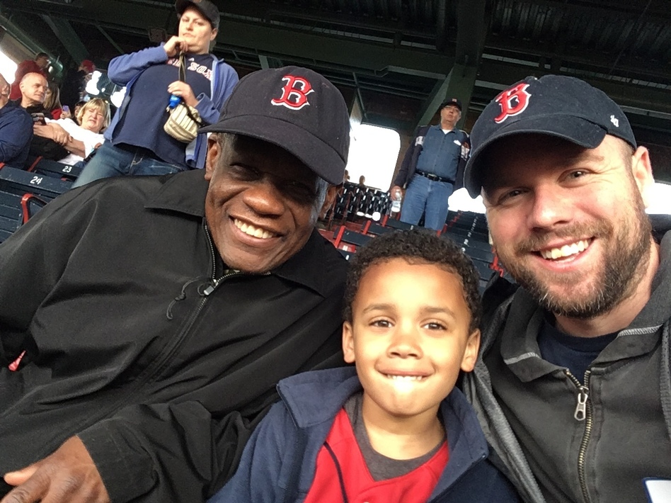 Calvin Hennick (right) attends a Red Sox game with his son, Nile, and his father-in-law, Guy Mont-Louis, at Boston's Fenway Park. Hennick reported a white fan who he said made a racist remark about a Kenyan woman who sang the national anthem. Photo: NPR.